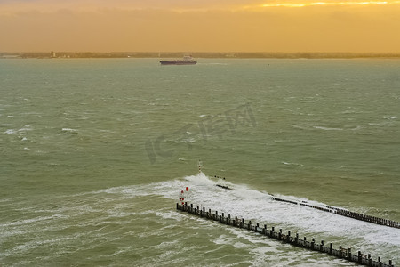 日落时分的弗利辛根港，一艘船从荷兰泽兰的野海景观中驶过