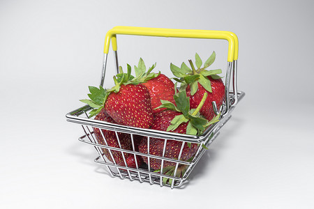 超市篮子里的草莓，白色背景特写