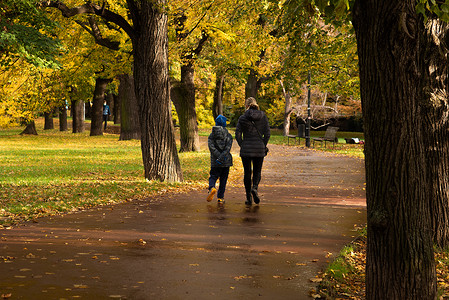 2020 年秋季，在捷克共和国冬季开始时，由于 COVID-19 爆发而导致隔离期间，母亲和儿子正在布拉格 6 号的 Letna 公园散步和交谈