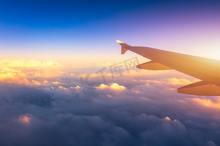 飞行和旅行，在日落时间从机翼上的飞机窗口查看。