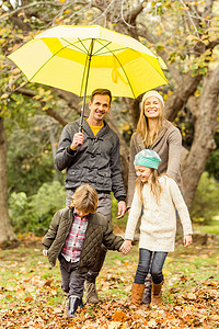 微笑的年轻家庭在伞下