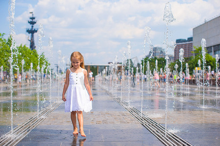 清爽一夏天摄影照片_大热天在户外喷泉玩得开心的可爱女孩