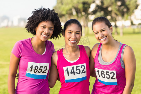 支持配合摄影照片_三位微笑的赛跑者支持乳腺癌马拉松