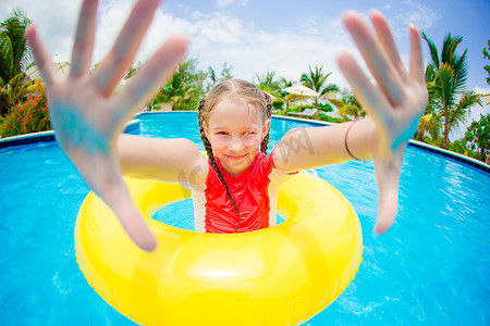 带充气橡胶圈的快乐儿童在游泳池玩乐的肖像