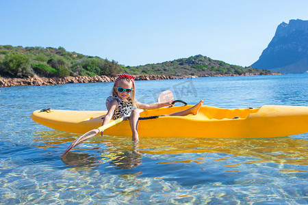 暑假期间在蓝色大海中划皮划艇的小可爱快乐女孩