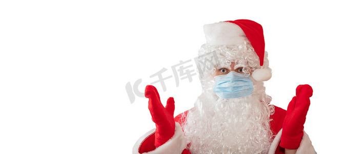 一个穿着圣诞老人服装和医用面具的男人双臂睁大眼睛，被白色背景隔离。