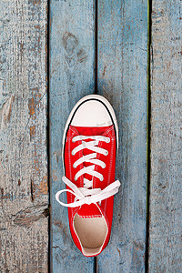 蓝色木质背景上的红色复古运动鞋