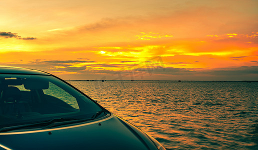 日落时分，蓝色紧凑型 SUV 车停在海边的水泥路上，采用运动和现代设计。