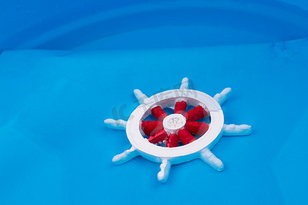 小的红色和白色模型小船方向盘在水中