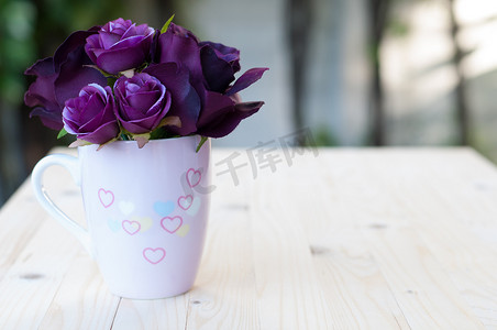 紫色杯子摄影照片_杯子里的紫色人造玫瑰为爱画心。