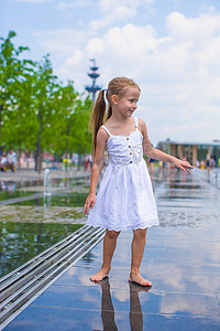 大热天，快乐的小女孩在户外喷泉里玩得开心