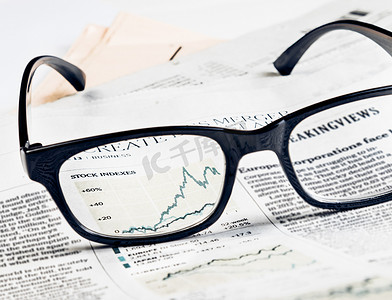 金融图表和股指图表通过金融报纸上的眼镜镜头看到