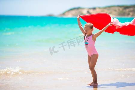 蓝色可爱风摄影照片_热带假期带沙滩巾的小女孩