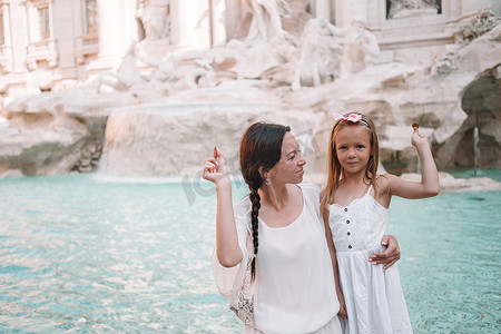 年轻漂亮的女人和小女孩靠近喷泉 Fontana di Trevi