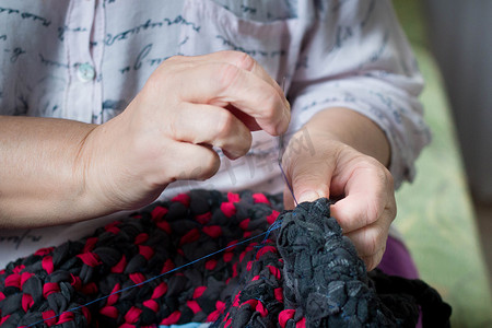 老妇人用针线做手工缝纫