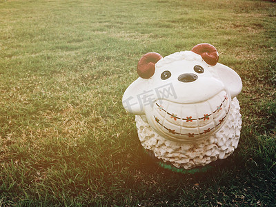 泥娃娃摄影照片_草地上羊娃娃灰泥的微笑