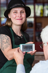 咖啡师拿着带优惠券代码的智能手机