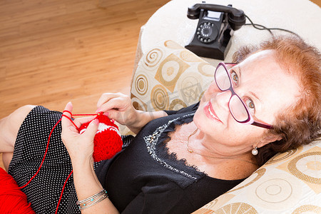 扶老人摄影照片_年长的祖母坐在椅子上编织