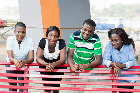 一群年轻的朋友靠在长凳上。