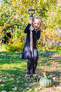 穿着万圣节女巫服装的可爱小女孩在扫帚上玩得开心
