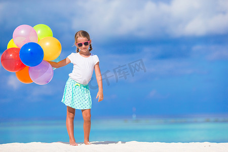 蓝色可爱风摄影照片_可爱的小女孩在沙滩上玩气球