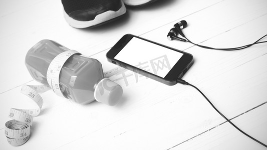 苹果手机黑色手机摄影照片_跑鞋、橙汁、卷尺和手机黑色和白色