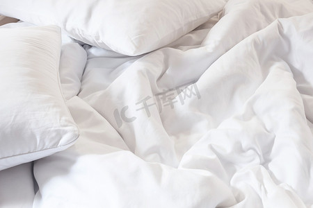 床和被子摄影照片_床上白色枕头的顶视图和皱纹凌乱的毯子我