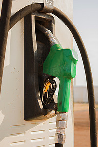 燃油摄影照片_加油站的燃油汽油分配器。手持燃油喷嘴为汽车加油。