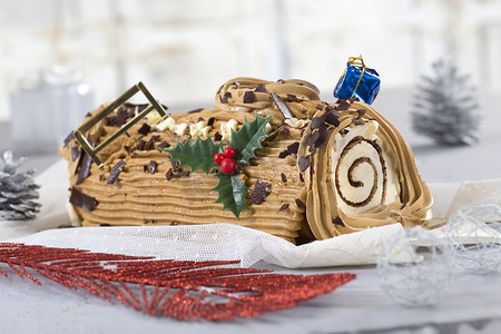 圣诞美食摄影照片_圣诞原木蛋糕，传统的圣诞面团和咖啡