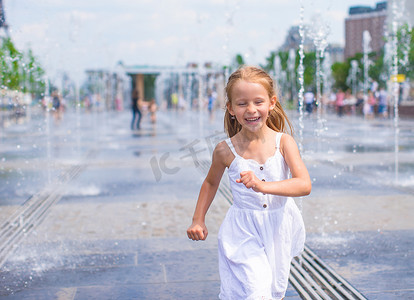 清爽一夏天摄影照片_大热天，快乐的小女孩在户外喷泉里玩得开心