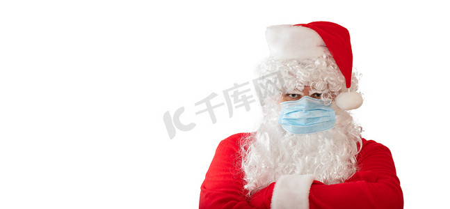 交叉传染摄影照片_一个身穿圣诞老人服装、戴着医用面具、双臂交叉在胸前的男子，在白色背景中被隔离。