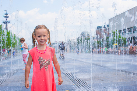 炎热公园摄影照片_可爱的小女孩在炎热的阳光明媚的夏日玩得开心