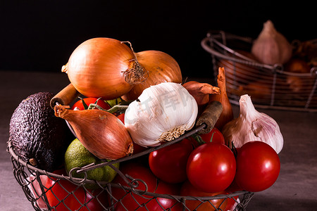 蔬菜海报装饰摄影照片_一个旧篮子的海报，上面有洋葱大蒜西红柿来装饰 t