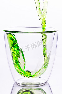将绿水倒入透明玻璃