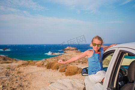 乘汽车度假旅行的小女孩背景令人惊叹的海景