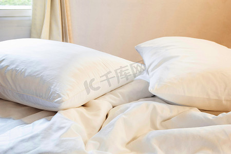 床和被子摄影照片_白色枕头和毯子，卧室床上皱纹凌乱