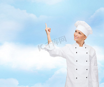 微笑的女厨师用手指指着某物