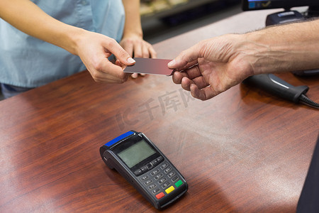 超市收银台摄影照片_在收银台用信用卡付款的女人