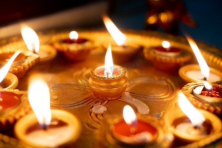 宏观照片显示彩色陶器 diya 油灯，用一点棉芯燃烧油灯，通常用作印度排灯节的装饰