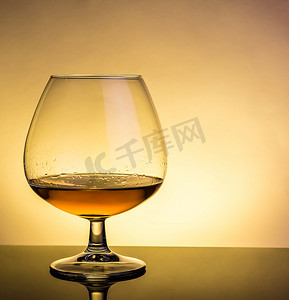 桌上优雅的典型干邑白兰地玻璃杯中的白兰地酒杯，带反射