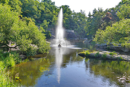 在炎热的夏日，在美丽的大自然中，在池塘中跳动的透明喷泉的美丽景色。