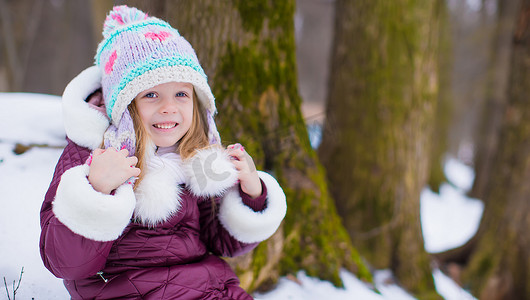 可爱的快乐小女孩在冬天的雪天户外玩得开心