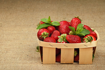 画布篮子里的草莓和薄荷叶