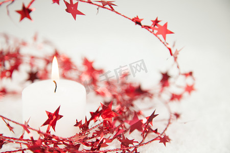 红色氛围装饰摄影照片_带烛光的红色圣诞星闪闪发光的装饰