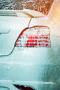 用肥皂清洗白色汽车的后视图。