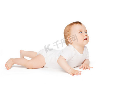 龙抬头好兆头摄影照片_微笑的婴儿躺在地板上抬头看