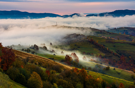 上升的雾覆盖了山区的农村田野