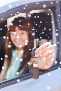 手拿车钥匙摄影照片_在户外拿着车钥匙微笑的女人的特写