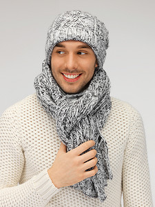 温暖的毛线衣、帽子和围巾的英俊的人