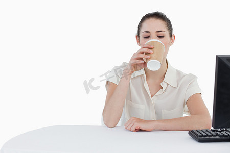 行政文员摄影照片_在使用电脑时喝外卖茶的女商人
